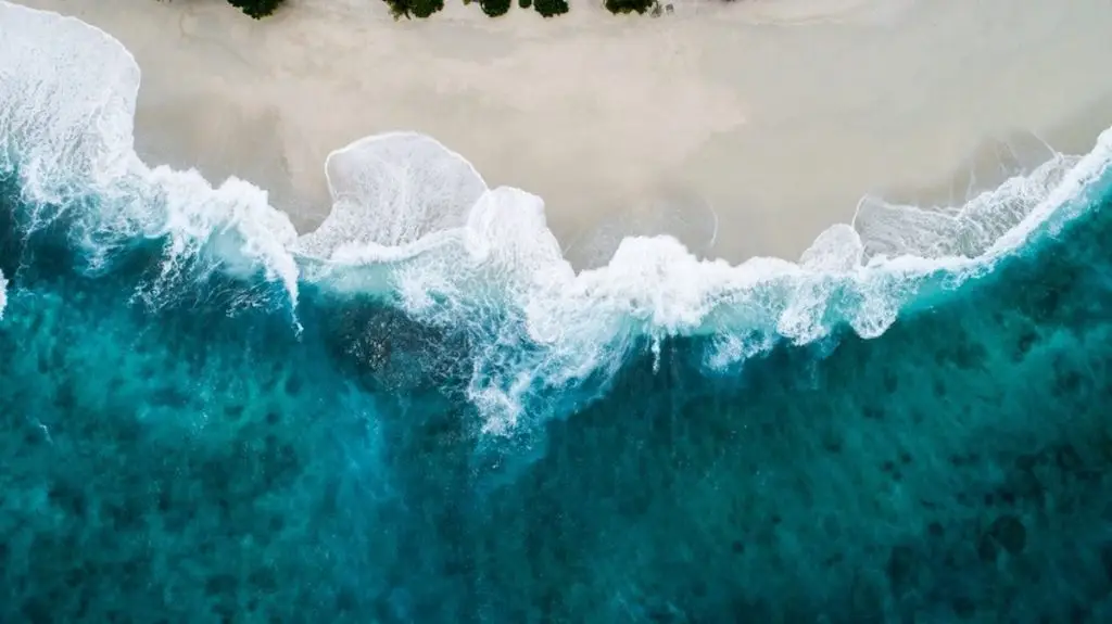 Aerial Shot Of Turquoise Sea Waves On The Beach